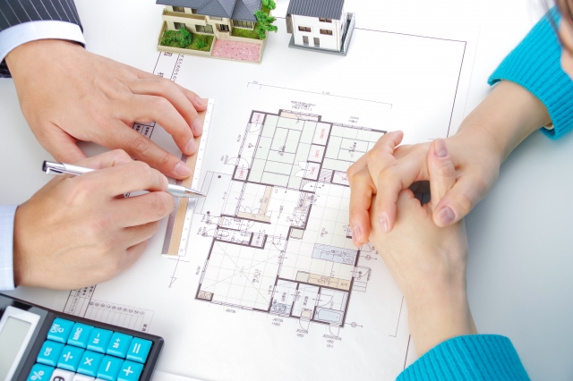 家の設計図と話し合う男女