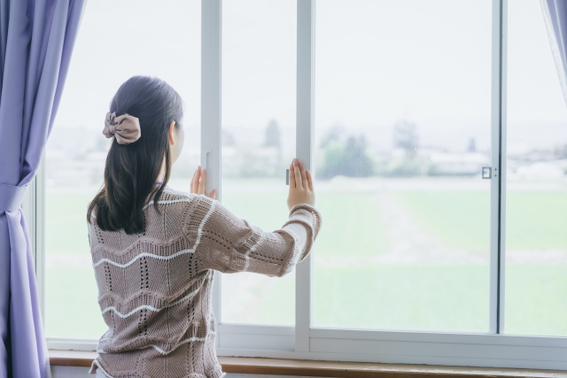 窓を開ける女性