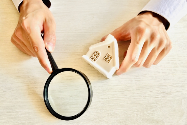 家の模型と虫眼鏡
