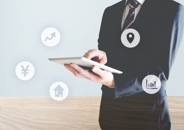 タブレットを使用するスーツの男性